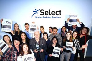 Mitarbeiter der Select GmbH heben die Leading Employer Auszeichnung in die Luft und freuen sich